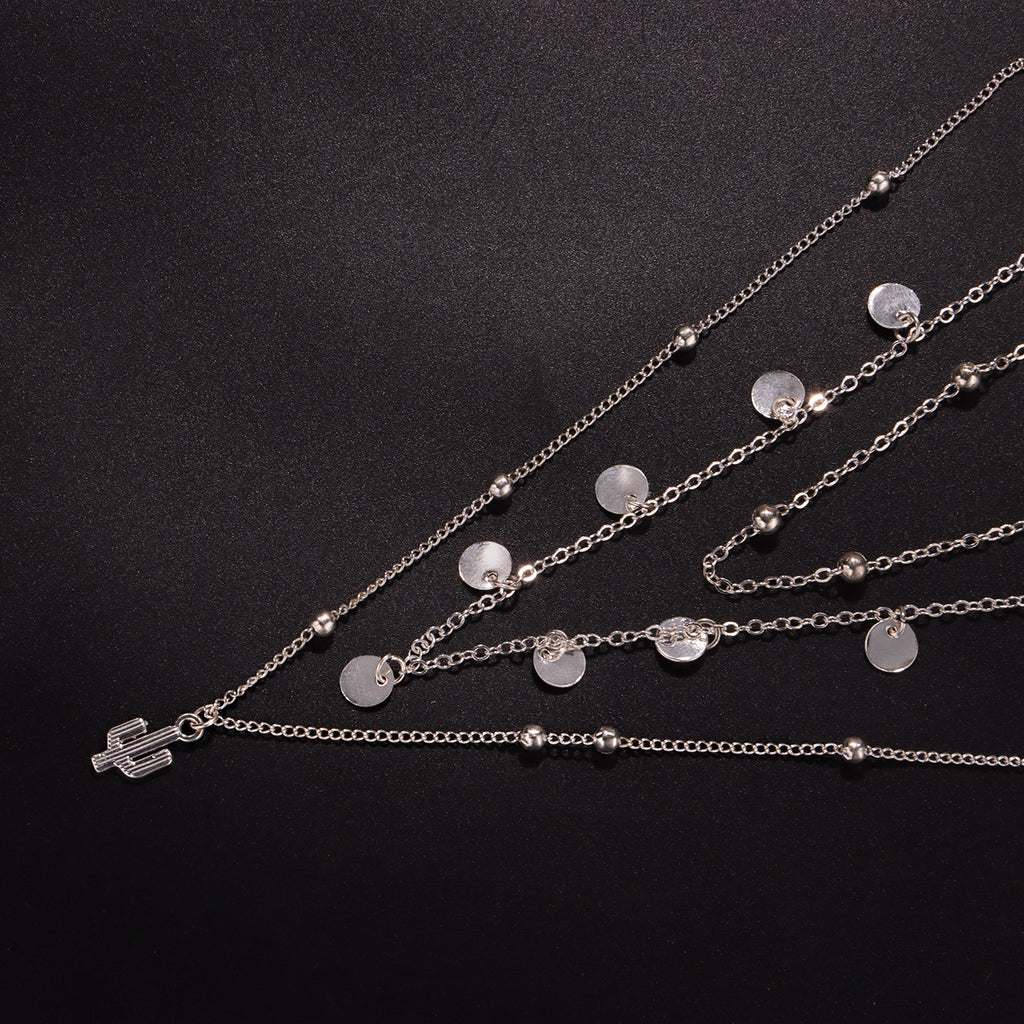 A multi-layered necklace featuring a round cactus pendant and a women's round bead chain